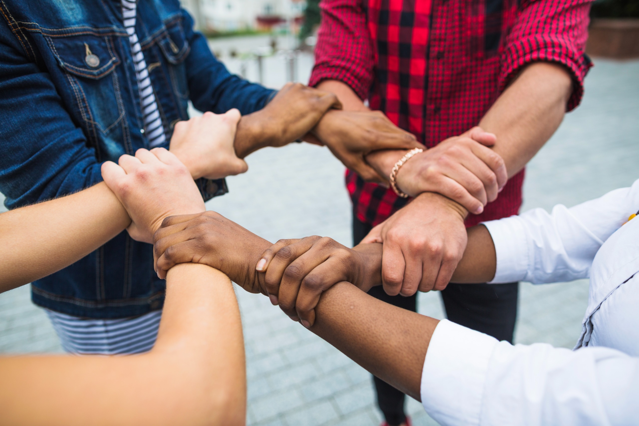 A diverse group linking arms in a circle