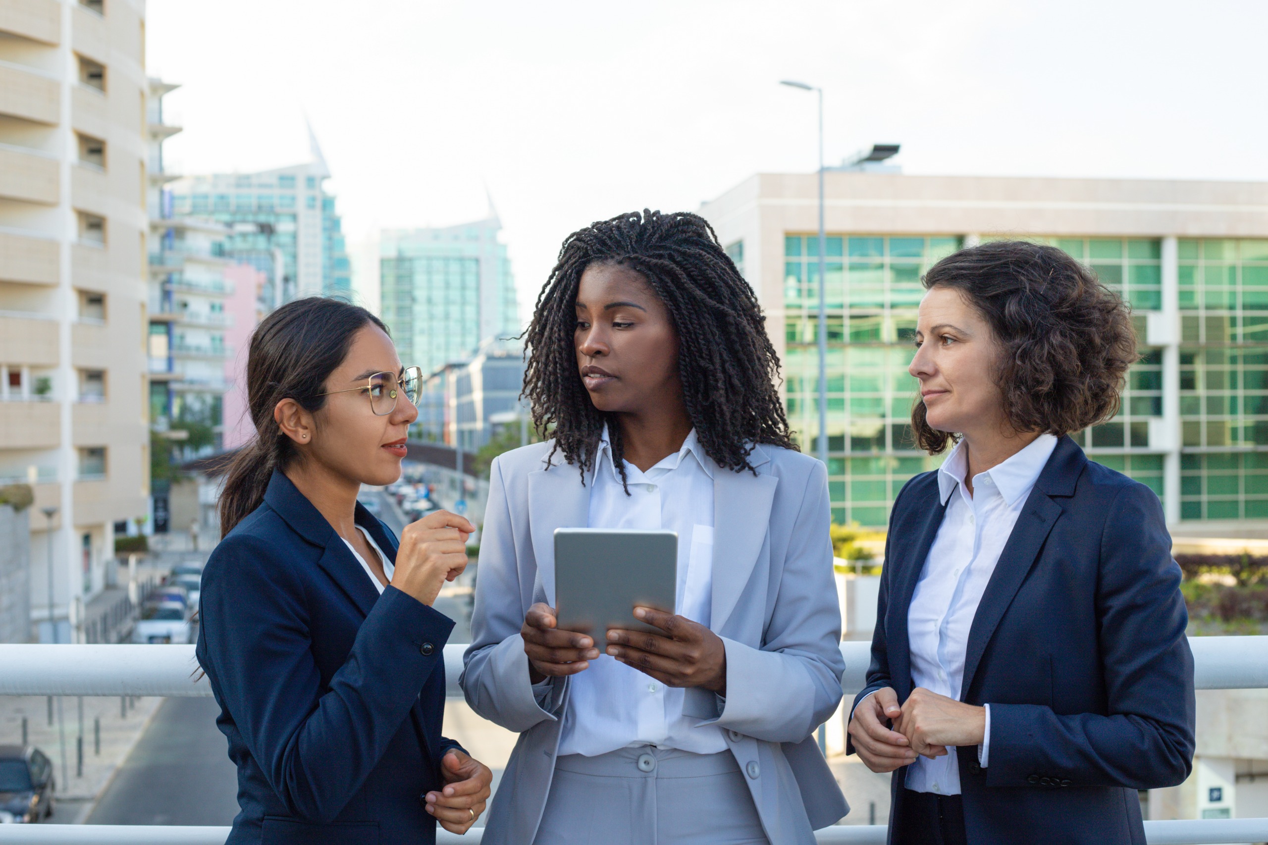 Three professionals exchanging ideas in an international city setting